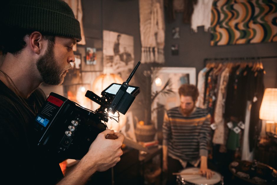 Snimatelj koristi kamernu opremu tijekom filmskog snimanja uz glazbenika u studiju